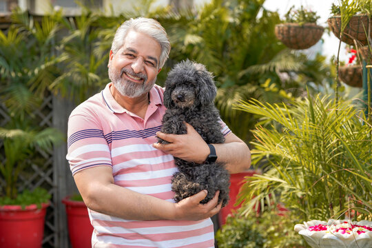 Indian senior man love with dogy puppy. concept about pets and animals.