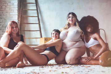 Group of four women with different body wearing nude lingerie and posing together to showing power...
