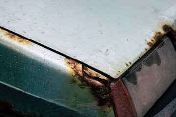 closeup of old and rusty car fender and hood. Neglected care of the vehicle