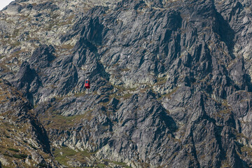 Obraz premium Red mountain cable car going up to the top of Lomnica Peak (Lomnický Peak, Lomnický štít ) in beautiful alpine High Tatras in Slovakia 