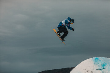 Breathtaking shot of a snowboarder while doing a spectacular trick in the air 
