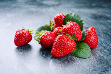 Reife rote Erdbeeren aus biologischem Anbau angeboten als close-up auf einem grauen Board mit Textfreiraum