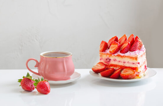 pink cup of coffee and strawberry cake on white background
