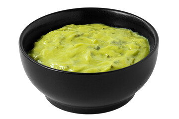 Guacamole dip in a black ceramic bowl isolated.