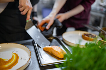 Chef cooking Roasted salmon steak with pumpkin cream on restaurant kitchen