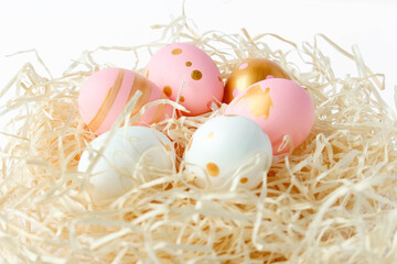 Fototapeta na wymiar Happy Easter concept. Colorful decorated easter eggs on an isolated white background. Fancy Easter pastel colored eggs in nest