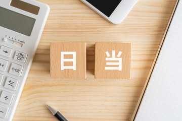 日当と書かれたブロック、電卓、スマホ、ノート、ペン