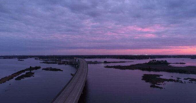 Aerial Shot Of Lake Pontchartrain Causeway Under Clouds, Drone Flying Forward During Dusk - New Orleans, Louisiana