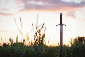 The ancient sword stuck in the ground background.