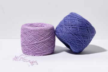 A set of purple skeins of knitting thread with a shade from hard light. Craft and hobby materials concept