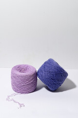 Vertical image of purple knitting yarn with shadow from hard light on gray isolated background. Conception of small business and handicrafts