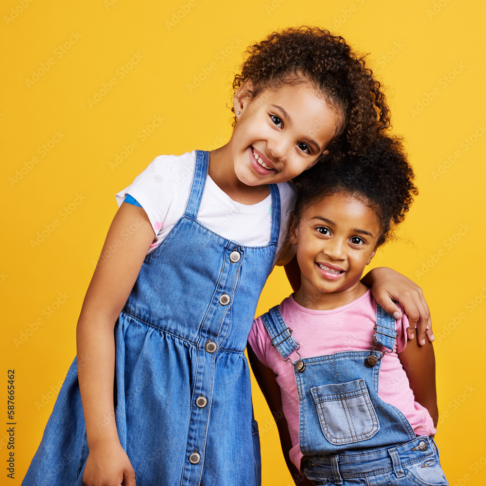 Wall mural Children, smile portrait and happy sisters in studio with love, care and support of family on yellow background. Cute young girl kids or friends together for happiness, hug or trust with mockup space