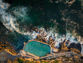 Aerial drone view of Bronte Ocean Pool in Sydney during sunrise in soft early morning light, New South Wales Australia - obrazy, fototapety, plakaty
