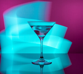 Martini cocktail in a glass against the background of neon lights