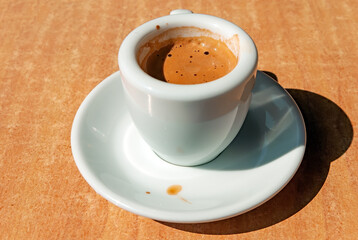 Espresso with foam in the white porcelain cup 