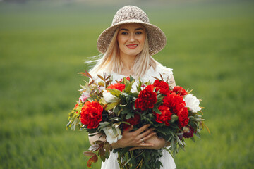 Woman in elegant dress standing in a summer field