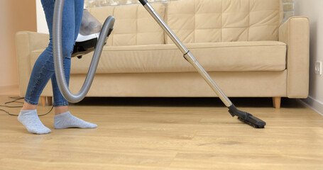 Young Woman cleaning Her house with Vacuum Cleaner