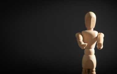 Wooden human figure on the grey background.