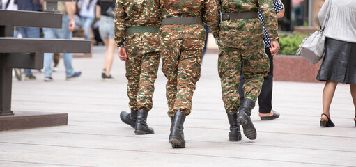 Soldiers on uniform walking in the city.