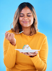 Woman, fork and cake in studio for dessert, satisfied or eyes closed for happiness by blue...