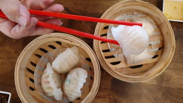 Hands chopsticks family eating dim sum Chinese breakfast food stuffed dumpling