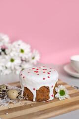 Easter cake with white icing with quail eggs and white flowers. decor with hearts