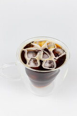 Fototapeta na wymiar Cup of coffee with ice cubes and lemon on white background.