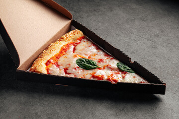 Take away box with a slice of giant margherita pizza