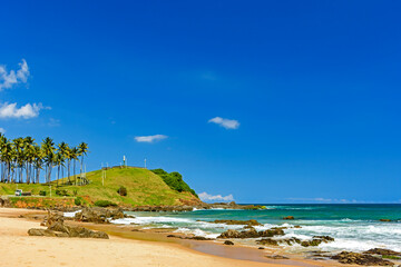 Christs hill surrounded by the beach, sea and the rocks at Barra beach in the center of Salvador in Bahia