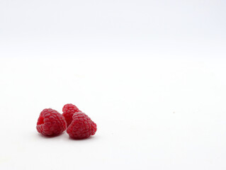 close up of ripe raspberries on a white background