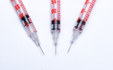 Trzy strzykawki z igłą do insuliny na białym tle