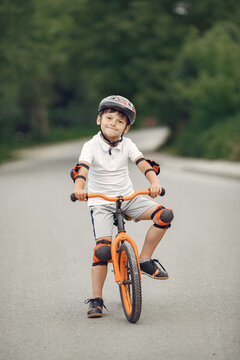 Boy in a helmet riding bike in a summer park