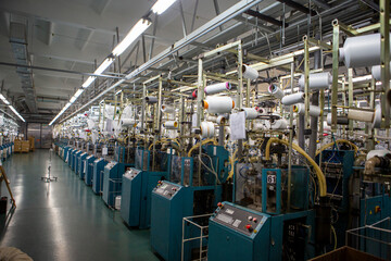Textile industry with knitting machines in factory. Textile industry with a loom on the production of kapron tights.