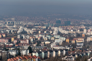 Obraz premium Cityscape of Banja Luka during sunny day, distant hill fade in hazy polluted air