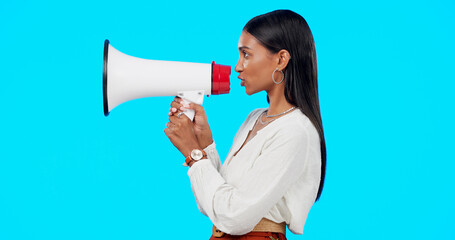 Megaphone, voice and announcement of woman isolated on blue background broadcast, breaking news and loud opinion. Indian person with speaker sound for gen z lifestyle or call to action sign in studio