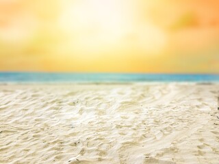 Natural scenery of yellow sky and white sandy beach. Selective focus on sand. Blurred natural background