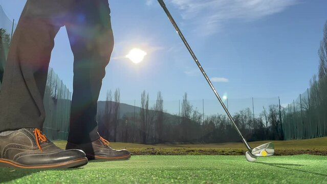 Golfer Training Golf Swing on Driving Range with Sunlight in Switzerland.