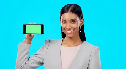 Fototapete Türkis Chroma key, green screen and businesswoman holding phone for product place, branding and mobile app advertising. Smile, happy and portrait of professional female isolated in a studio blue background  © Nina/peopleimages.com