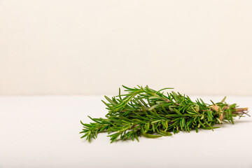 Rosemary on a white textured wooden background. Fresh spice herbs. Seasoning for meat and fish. Recipe. Organic bouquet of fresh rosemary on the table. Place for text. Place to copy.