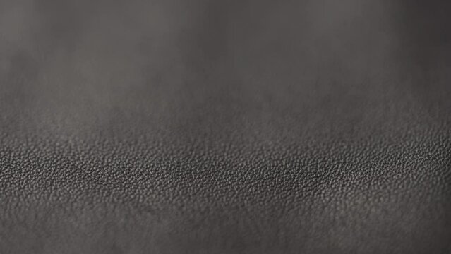 Slow motion closeup slide shot of soft gray brown leather