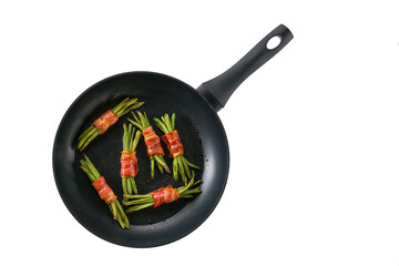 Pan with baked appetizer, bundles of green beans wrapped in bacon isolated on a white background....