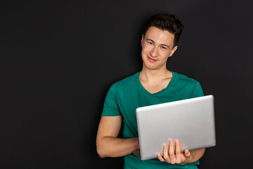 Handsome European Man Working on Laptop Computer while Sitting on a Sofa in Cozy Living Room. Freelancer Working From Home. Browsing Internet, Using Social Networks, Having Fun in Flat.