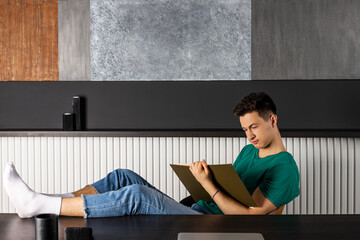 Obraz premium Portrait of attractive young businessman reading at workplace. Education concept