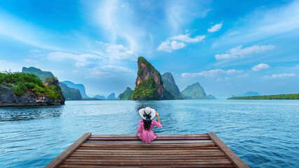 Tourist sitting on wooden bridge in Phang nga bay, Thailand.
