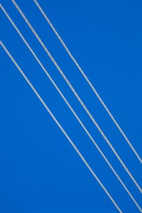 High-voltage power line wires close-up against a blue sky background