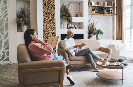 Diverse aged women reading books in living room