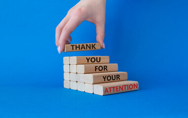 Attention symbol. Wooden blocks with words Thank you for your attention. Beautiful blue background....