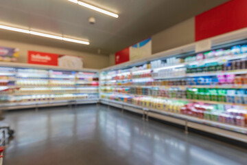 The defocused blur of supermarket drink shelves with dairy products. Blur background with bokeh.