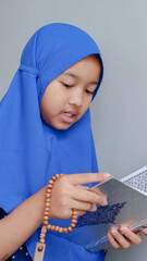 Fototapeta premium Pretty Muslim Girl Studying Holy Book of Quran