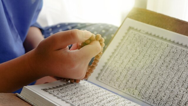 Conceptual image of religion. Holy tasbih or islamic prayer beads and Quran. Ramadan theme background.